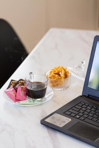 a laptop computer sitting on a table next to a plate of food at Artemis Cynthia Complex in Paphos City