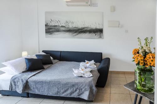 a bedroom with a bed and a vase of flowers at Artemis Cynthia Complex in Paphos City