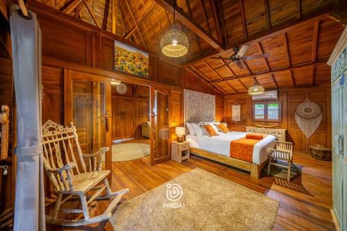 a bedroom with a bed and chairs in a room at Rumah joglo in Candidasa