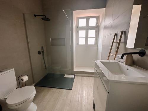 ein Badezimmer mit Toilette und Waschbecken und einem Fenster in der Unterkunft Casa Boa Vista - Charming House in Angra do Heroísmo