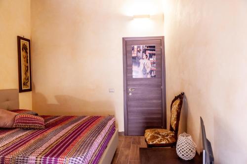 a bedroom with a bed and a door with a chair at B&B Piazza Noua 1831 in Sora