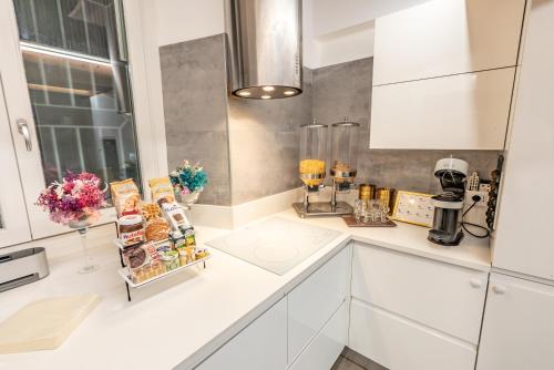 a kitchen with white cabinets and a counter top at Luxe & Central Haven - Jacuzzi, Sauna, Steam, Private Parking in Como