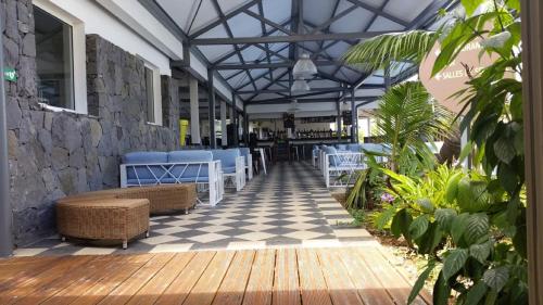 a patio with chairs and a checkered floor at Les Aigrettes in Saint-Gilles les Bains