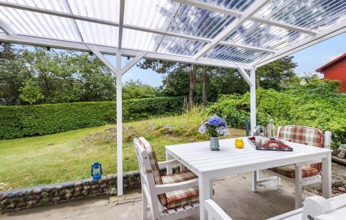 a white pergola with a table and chairs on a patio at 2 Bedroom Cozy Home In Allinge in Allinge