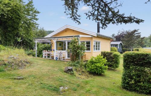 a small yellow house with a table in a yard at 2 Bedroom Cozy Home In Allinge in Allinge