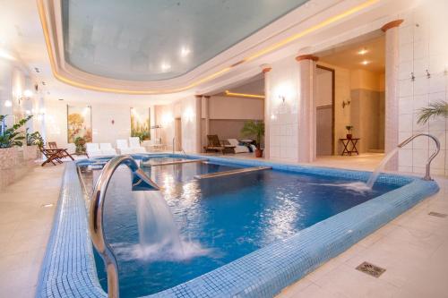 a large swimming pool in a hotel room with a swimming poolvisor at Batthyány Kastélyszálló in Zalacsány