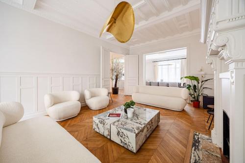 un salon avec des meubles blancs et une table dans l'établissement Amazing Apartment # 5Bedrooms #Paris 16 #Trocadero, à Paris