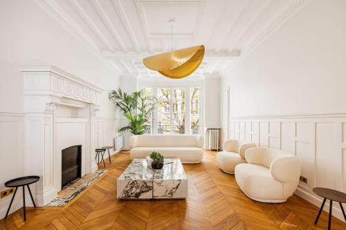 un salon avec des meubles blancs et un lustre doré dans l'établissement Amazing Apartment # 5Bedrooms #Paris 16 #Trocadero, à Paris