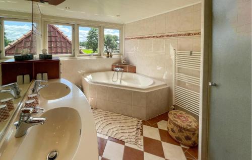 a bathroom with a tub and a sink at Nice Home In Oudeschoot With Wifi in Oudeschoot