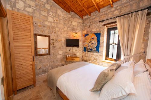 a bedroom with a bed in a stone wall at Derviş Bey Konağı in Urla