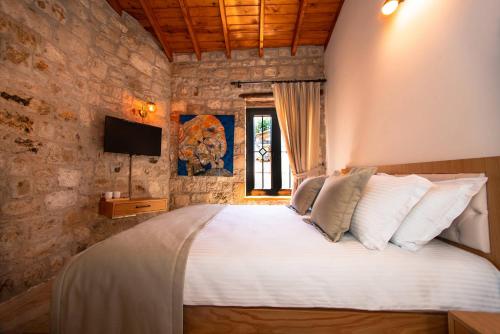 a bedroom with a large bed in a stone wall at Derviş Bey Konağı in Urla