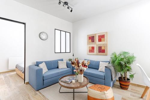 un salon avec un canapé bleu et une table dans l'établissement Résidor - Appartement 4P chaleureux et lumineux !, à Paris