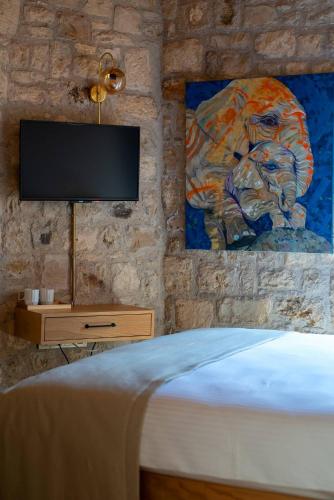 a bedroom with a bed with a television on a wall at Derviş Bey Konağı in Urla