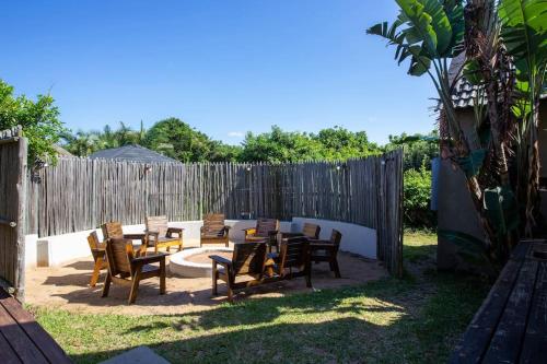 a patio with tables and chairs and a fence at Baleia Azul 15 in Ponta do Ouro
