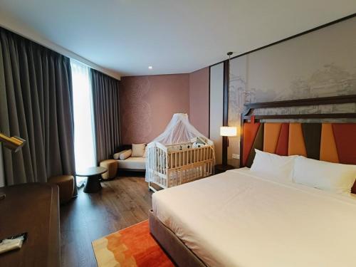 a hotel room with a bed and a crib at Apec Mandala Mui Ne Beach Studio in Ấp Thiẹn Ái