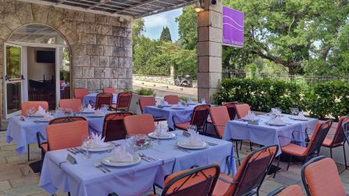 a group of tables and chairs with blue table cloths at Hotel Komodor in Dubrovnik