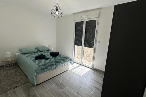 a bedroom with a bed and a large window at Grande maison en sologne in Romorantin