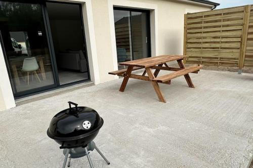 un gril avec un casque dessus à côté d'une table de pique-nique dans l'établissement Grande maison en sologne, à Romorantin-Lanthenay