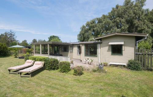 a small house in a yard with a bench at 2 Bedroom Amazing Home In Stege in Stege