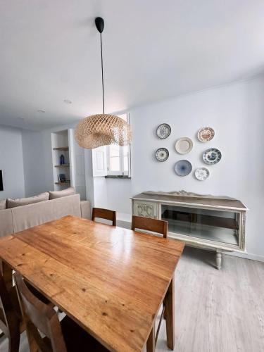 a dining room with a wooden table and a couch at Casa Boa Vista - Charming House in Angra do Heroísmo