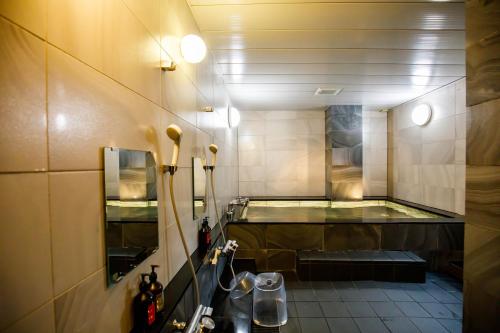 a bathroom with a tub in the middle of a room at Hotel Sunplaza 2 Annex in Osaka