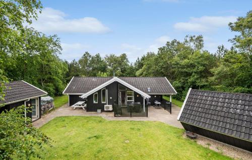 a black house with a large yard in front of it at Beautiful Home In Oksbøl With Sauna in Oksbøl