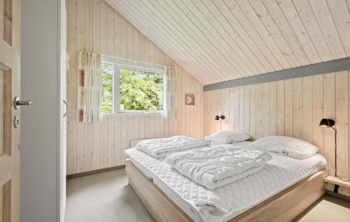 a bedroom with a large bed in a room with a window at Beautiful Home In Oksbøl With Sauna in Oksbøl