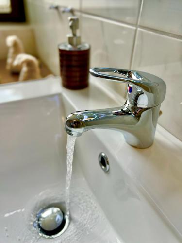 a sink with water coming out of a faucet at Peedy's luxuriöse 60m² Wohnung mit Balkonterrasse in Stade