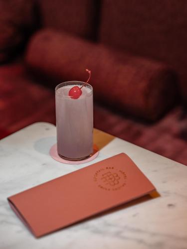 a candle with a cherry on a table with a card at Boudoir des Muses in Paris