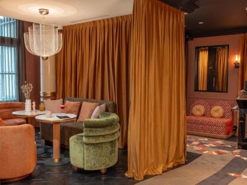 a living room with a couch and a table at Boudoir des Muses in Paris