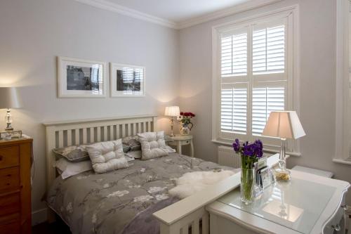 a bedroom with a bed and a desk and a window at Windsor Road Retreat in Richmond