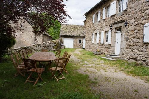 a table and chairs in front of a stone building at Village de gîtes de Sainte-Lucie in Sainte-Lucie