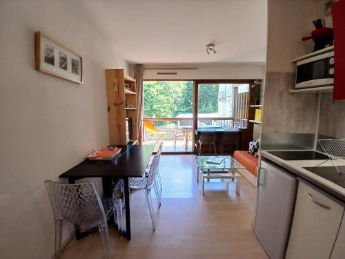 une cuisine et un salon avec une table et des chaises dans l'établissement La Pique, à Luchon