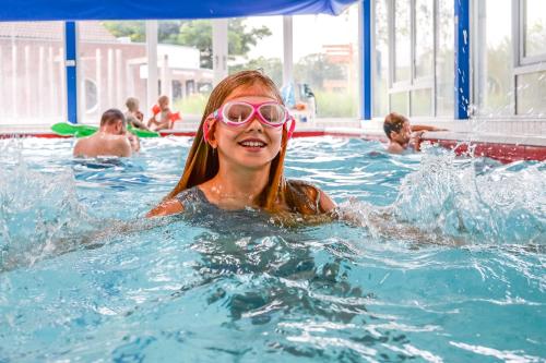 a young girl in a swimming pool wearing goggles at Slow Living bij Mölke x Wellnesslodges in Zuna