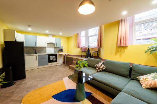 a living room with a couch and a kitchen at Aaron Wise - 51 Fitzhamon Apartments in Cardiff