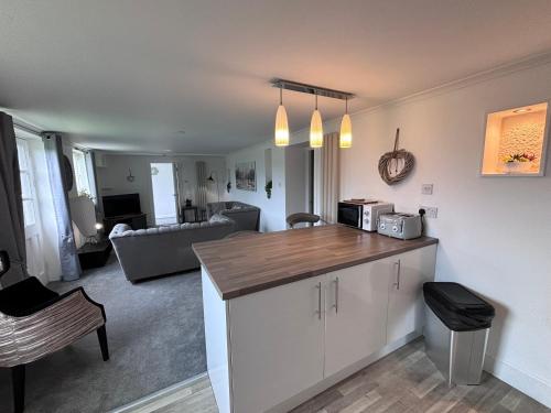 a kitchen with a counter and a living room at Richmond Park Hotel in Boʼness