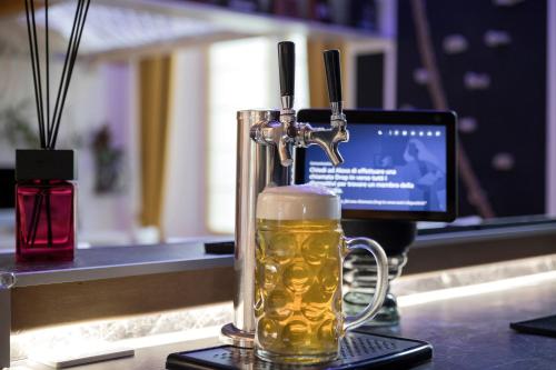 a glass mug of beer on a counter with a computer at Luxe & Central Haven - Jacuzzi, Sauna, Steam, Private Parking in Como