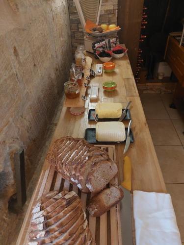 a long table with bread and other food on it at Le Moulin du Porteil in Campagne