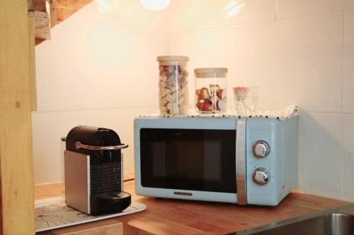 un four micro-ondes assis sur un comptoir à côté d'un grille-pain dans l'établissement Madame paris, à Villejuif