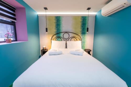 a bedroom with a white bed with a colorful wall at Aaron Wise - 51 Fitzhamon Apartments in Cardiff