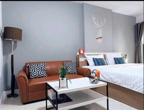 a living room with a couch and a bed at Studio 1 bed heart old town phuket convenience in Ban Sam Kong