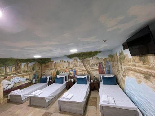 a room with couches and a painting on the wall at Jumadaler Дворец эмира в старом городе in Bukhara