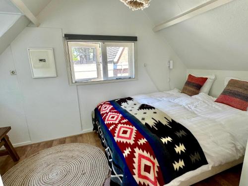 a bedroom with a bed and a window at Vakantiehuis Flori in Bergen