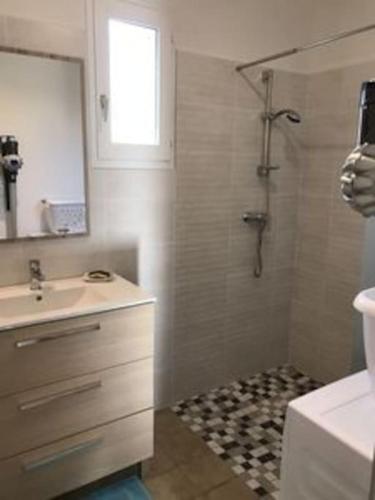 une salle de bain avec un lavabo et une douche avec un miroir dans l'établissement Maison de vacance proche de la plage, à La Brée-les-Bains