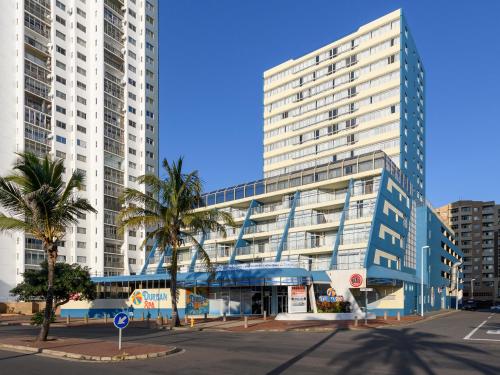 Un gran edificio con palmeras delante. en Durban Spa, en Durban