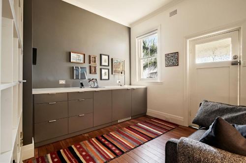 a kitchen with a sink and a window and a couch at Coogee Treetops in Sydney