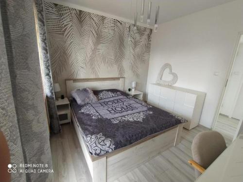 a bedroom with a bed with a black and white comforter at Willa Loka Apartamenty in Władysławowo