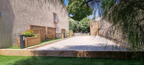 a driveway in front of a building with a fence at Villa accueillante entre Aix et Marseille in Vitrolles