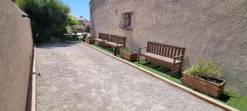 two benches sitting next to a building with plants at Villa accueillante entre Aix et Marseille in Vitrolles
