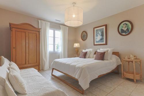 une chambre avec un grand lit blanc et une fenêtre dans l'établissement Villa Rosalie, à Rochefort-du-Gard